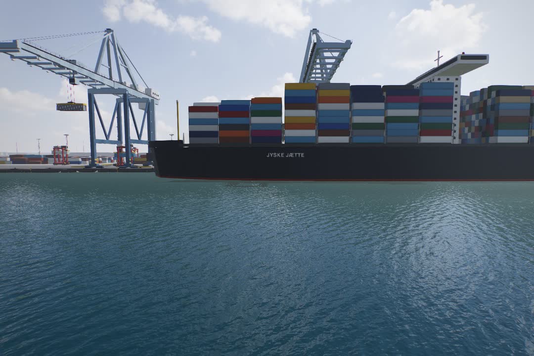 Et stort containerskib ved kajen under to containerkraner, set fra vandet.